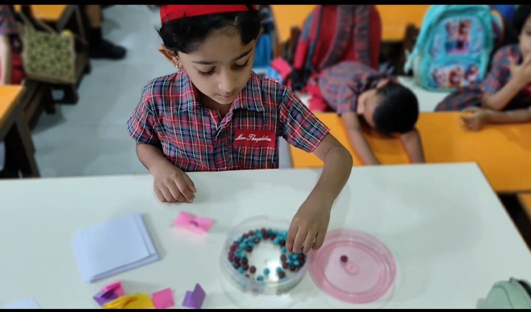 Student counting blue and purple beads in bowl