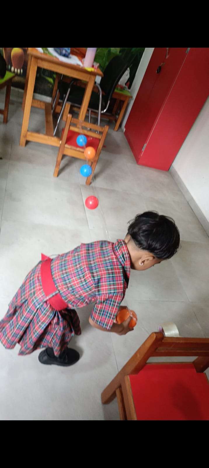 Sticking colorful plastic balls on hanging tape lines