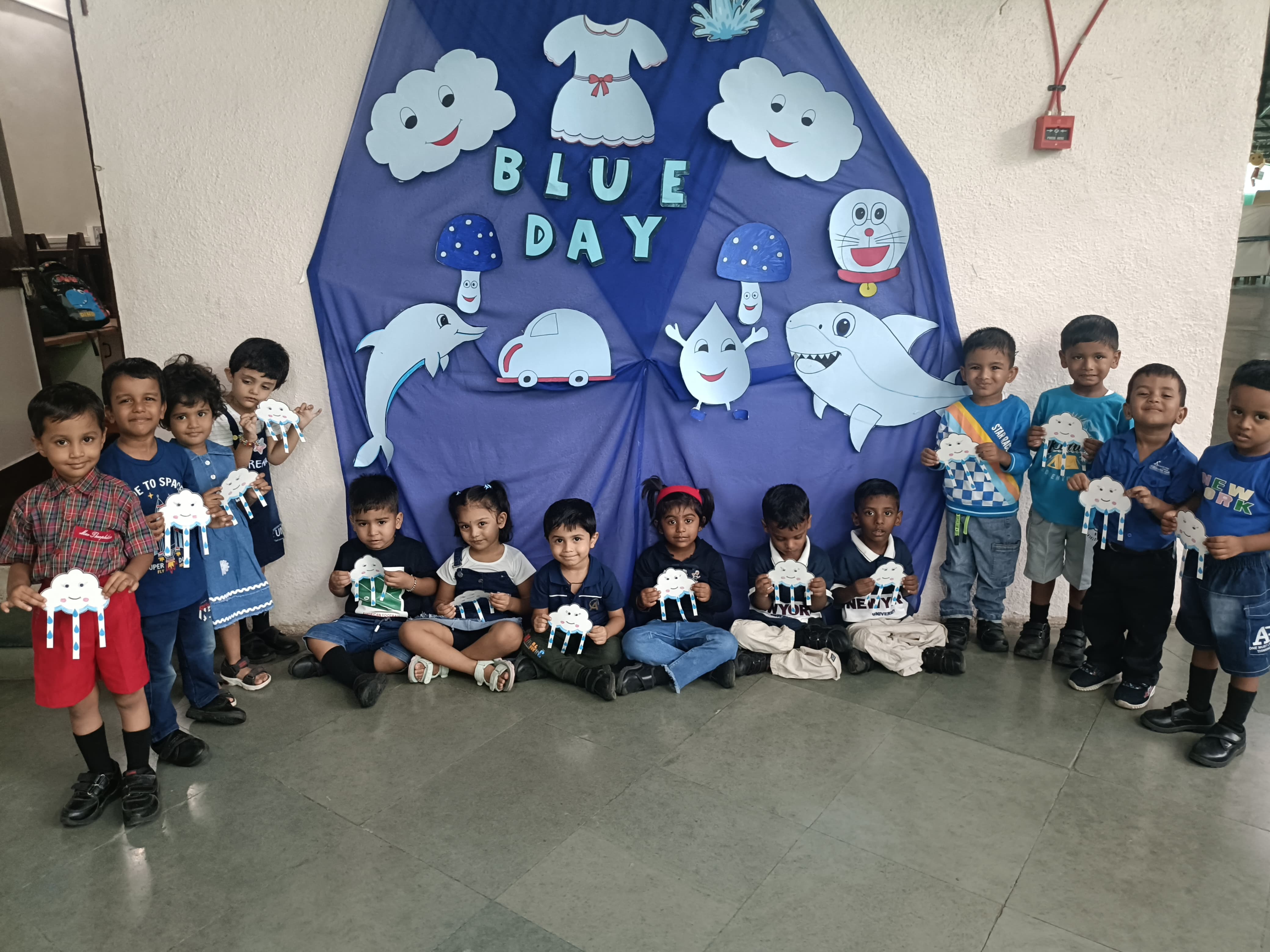 Group - Children in blue dress posing with raindrop cards